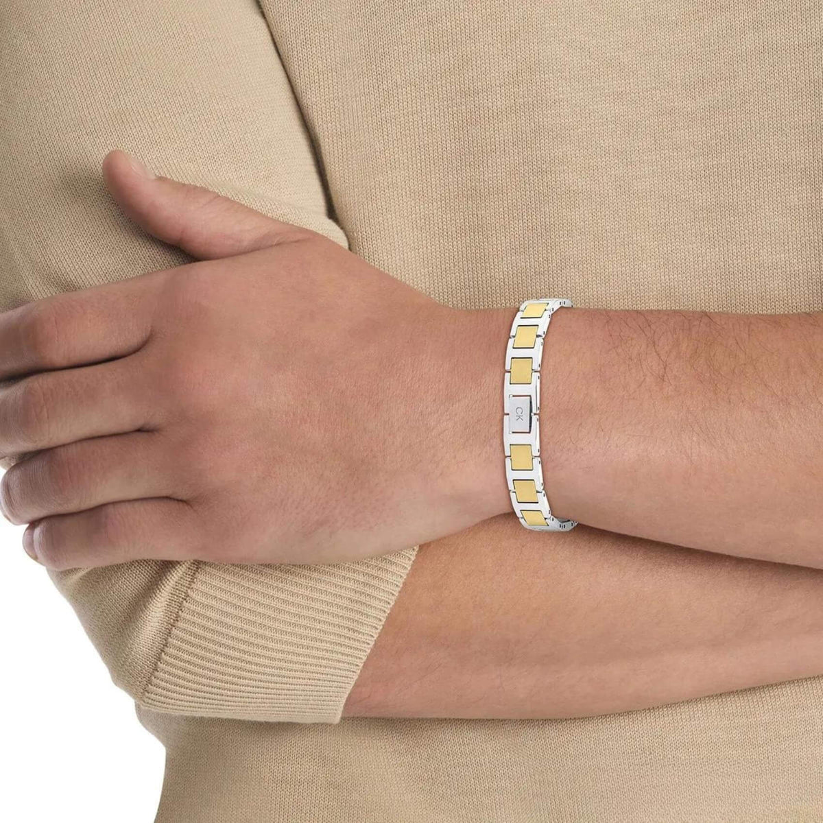 Ανδρικό βραχιόλι ταυτότητα Calvin Klein 35100009 δίχρωμο σε ασημί-χρυσό χρώμα κατασκευασμένο από χειρουργικό ατσάλι σε σχέδιο μπρασελέ, φορεμένο.