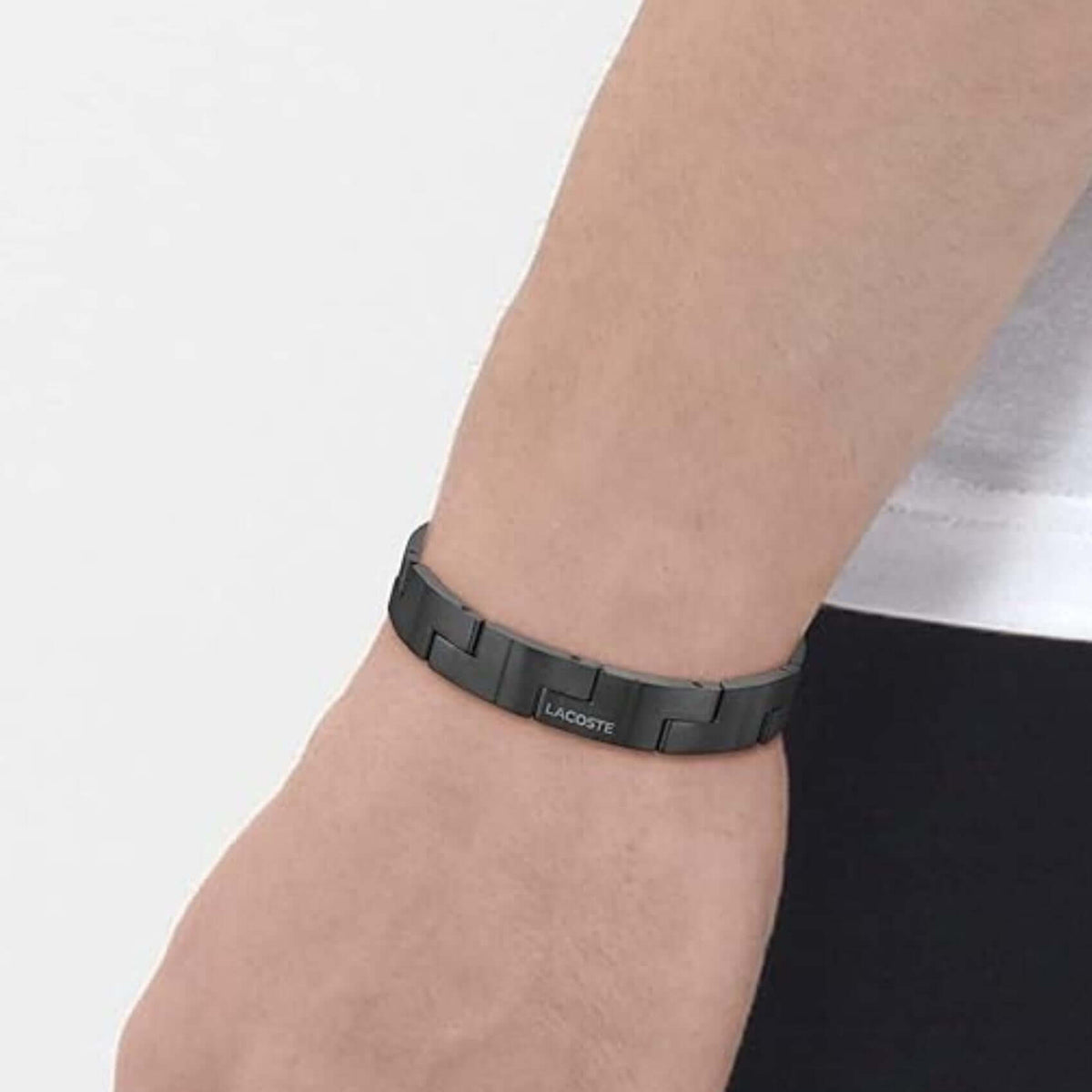 Ανδρικό βραχιόλι Lacoste Catena 2040222 φορεμένο στον καρπό, χειροπέδα από ανοξείδωτο ατσάλι σε μαύρο χρώμα.