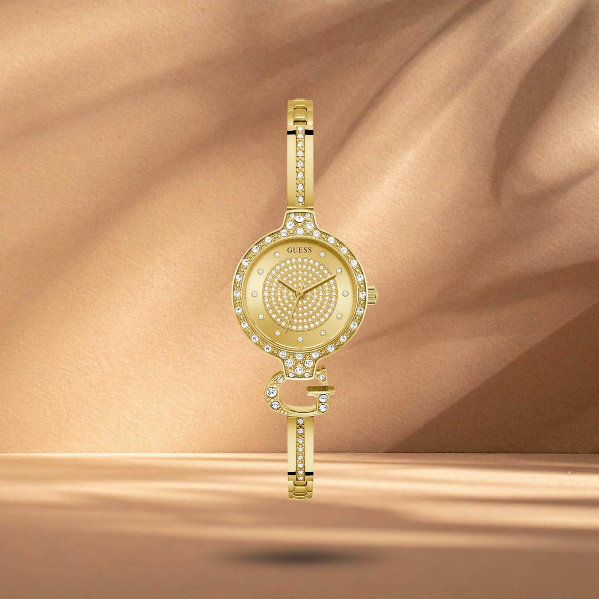 Guess GW0929L2 γυναικείο ρολόι με χρυσό ατσάλινο μπρασελέ σε ιδιαίτερο σχέδιο βραχιολιού, χρυσό καντράν διαμέτρου 28mm και στεφάνη διακοσμημένη με ζιργκόν.