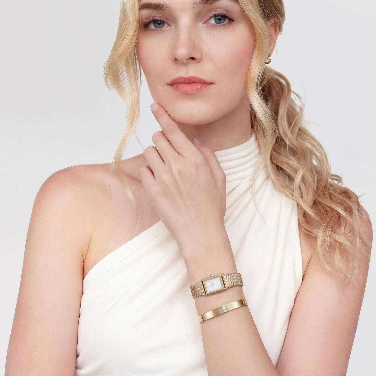 Γυναικείο ρολόι Daniel Wellington Bound Mini Mesh DW00100928 φορεμένο με χρυσό ατσάλινο μπρασελέ και λευκό τετράγωνο καντράν.