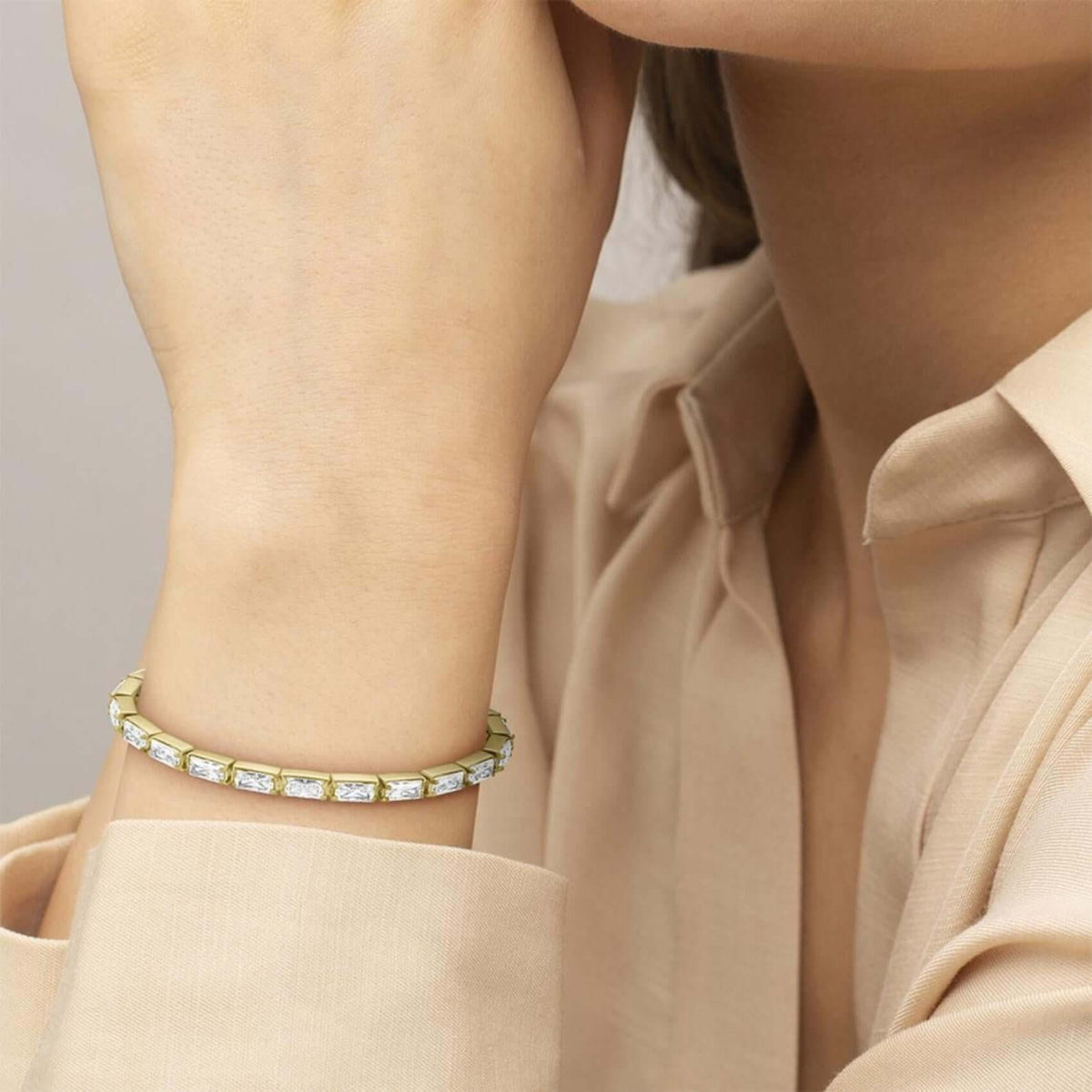 Μοντέλο φορά το γυναικείο βραχιόλι Lacoste Duchess 2040499 σε χρυσό χρώμα διακοσμημένο με ζιργκόν