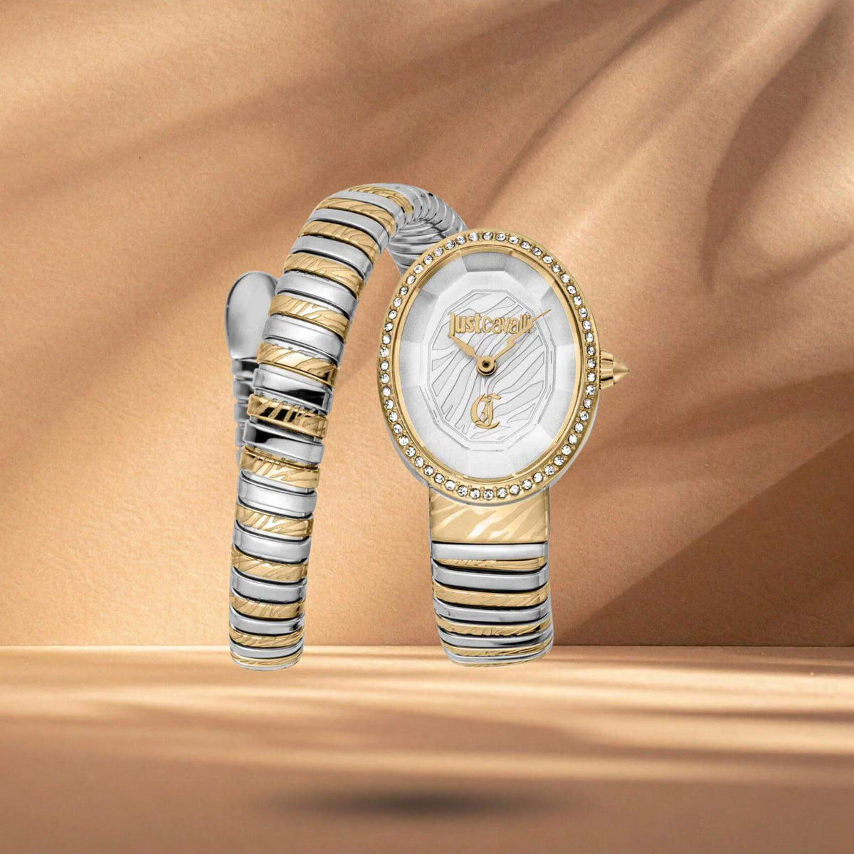 Just Cavalli JC1L353M0055 γυναικείο ρολόι με δίχρωμο ατσάλινο μπρασελέ σε ασημί-χρυσό χρώμα, ασημί οβάλ καντράν μεγέθους 22x31.5mm και χρυσή στεφάνη με λαμπερά ζιργκόν.